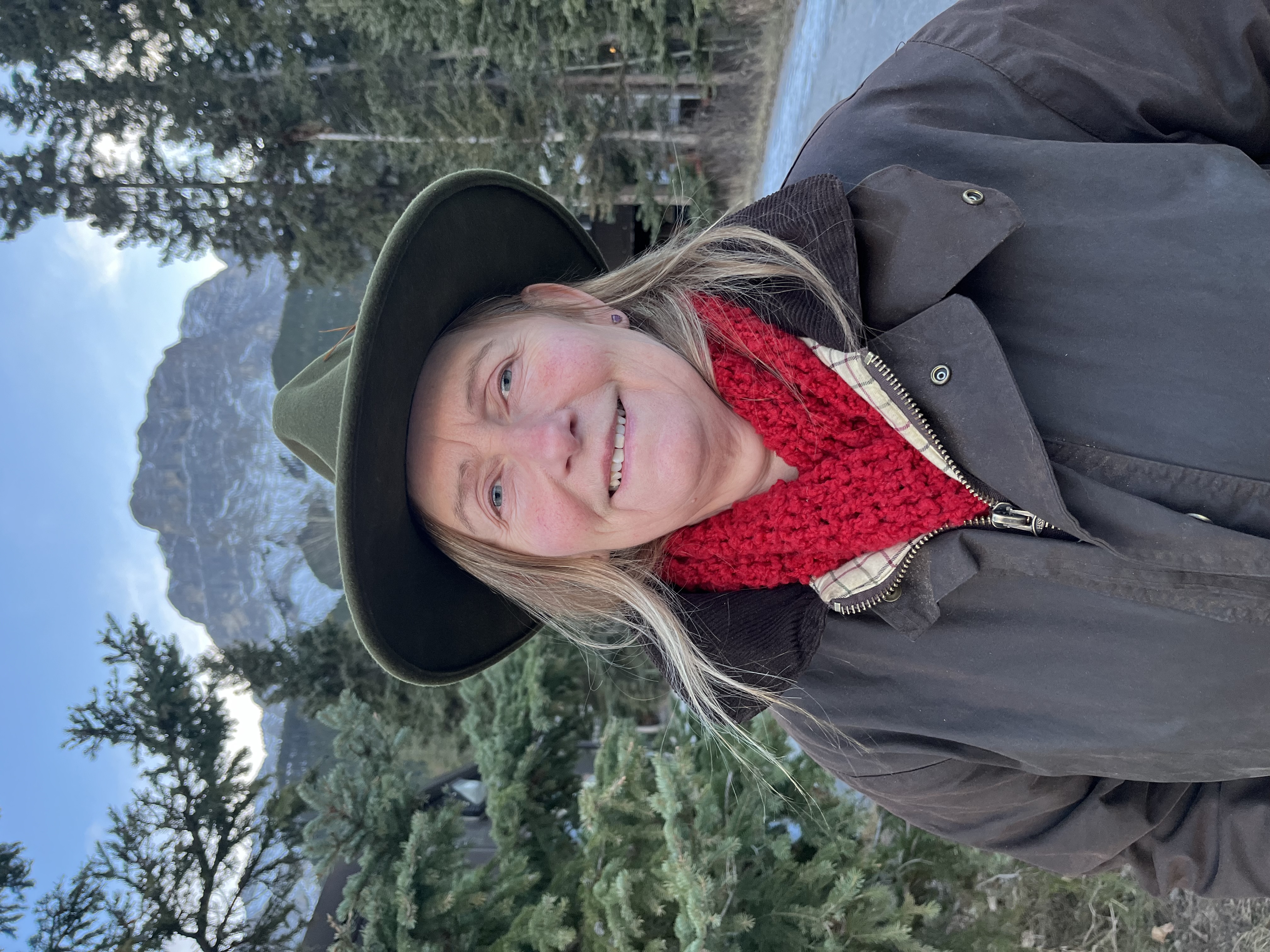 woman in red scarf and wax jacket outside in the mountains